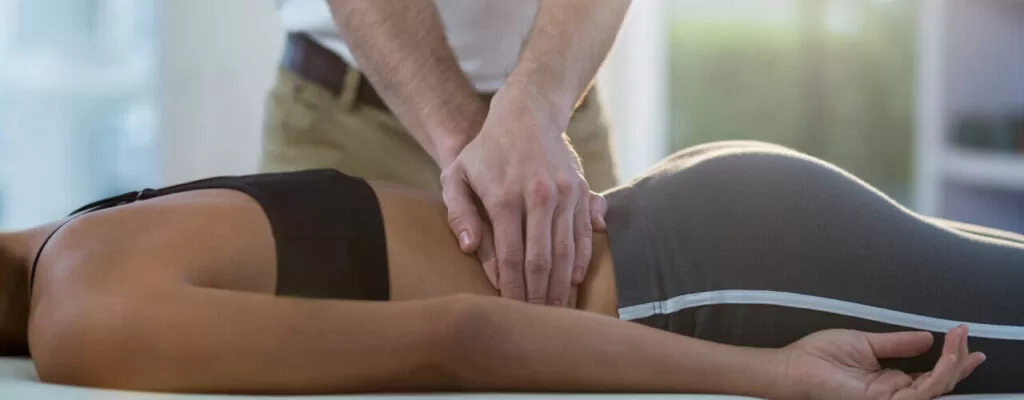 A lady getting physical therapy treatment for her back pain
